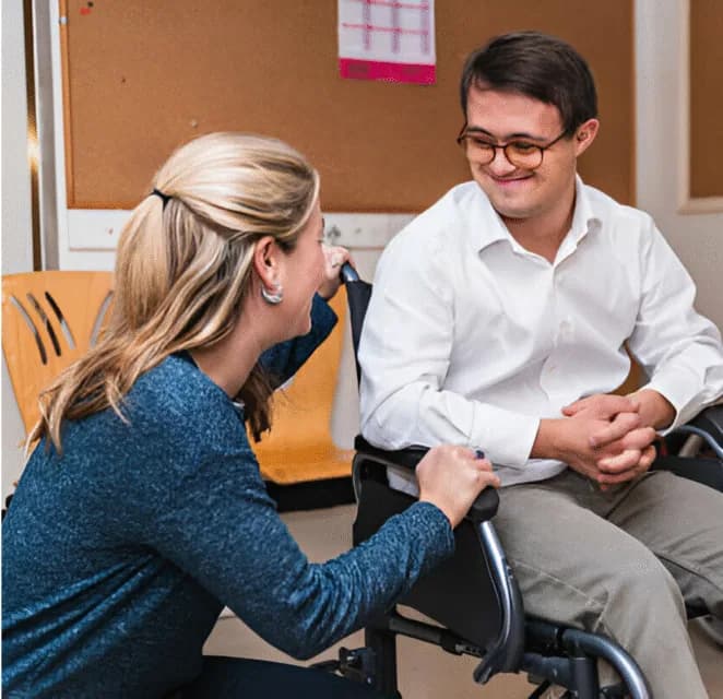 A support professional talking with a wheelchair user