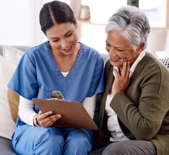 A personal care professional reviewing a care plan with an older adult